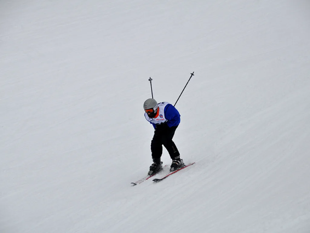 Skifahrer in tiefer Hocke auf der Piste.